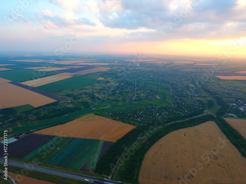 Aerial view of beautiful village, houses, roads. Sky, clouds, sunset.