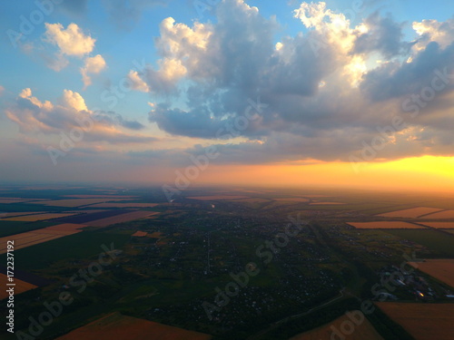Aerial view of beautiful village, houses, roads. Sky, clouds, sunset.