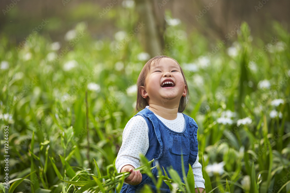 happy little asian girl in spring field happy little asian girl in spring field