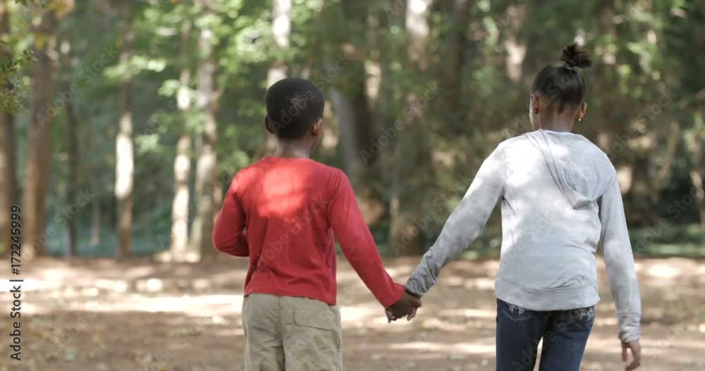 Cute little boy & girl holding hands & walking in the woods Cute little boy & girl holding hands & walking in the woods