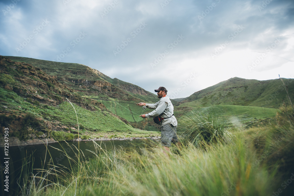 fly fisherman casting into a wilderness river fly fisherman casting into a wilderness river