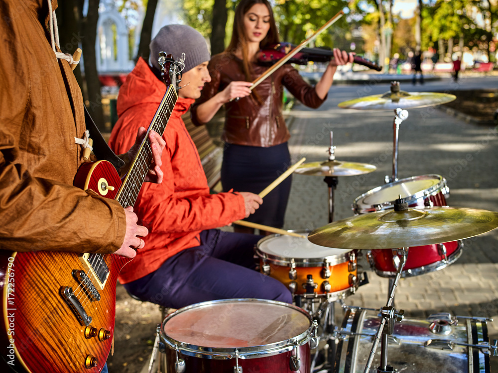 Festival music band. Hands playing on percussion instruments in city park. Drums with sticks closeup. Body part of male musicians. Autumn street musician makes money for a living.