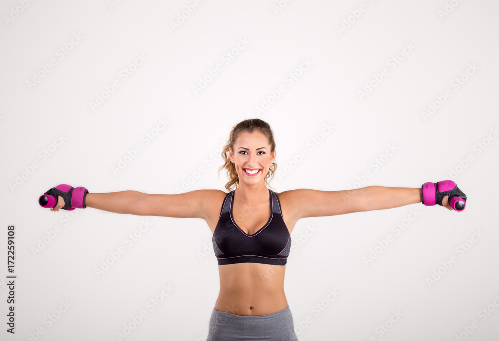 Happy fitness woman holding dumbbells and smiling Happy fitness woman holding dumbbells and smiling