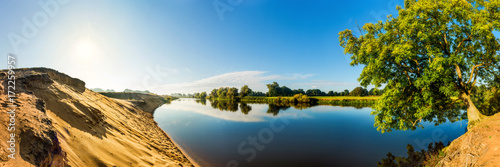 Summer landscape with river, sun and blue sky