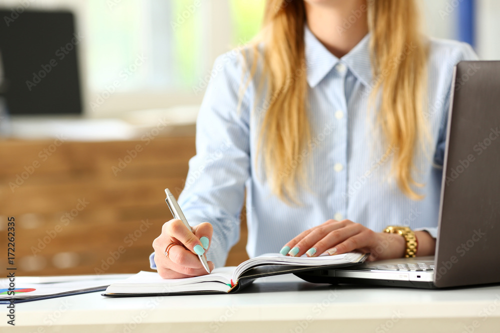 Female arm in suit hold silver pen making note Female arm in suit hold silver pen making note