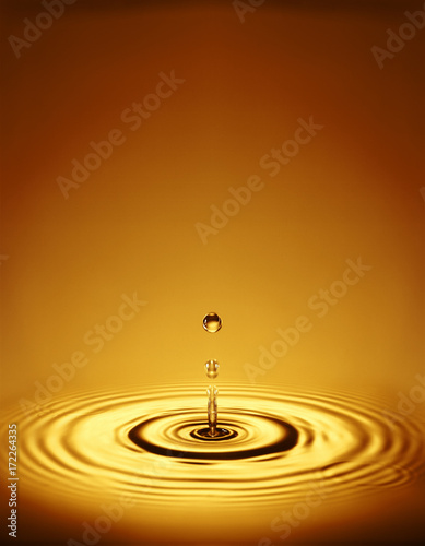 Droplet with ripples in amber liquid