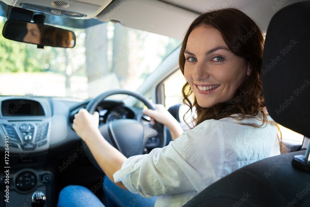 Beautiful smiling woman driving a car