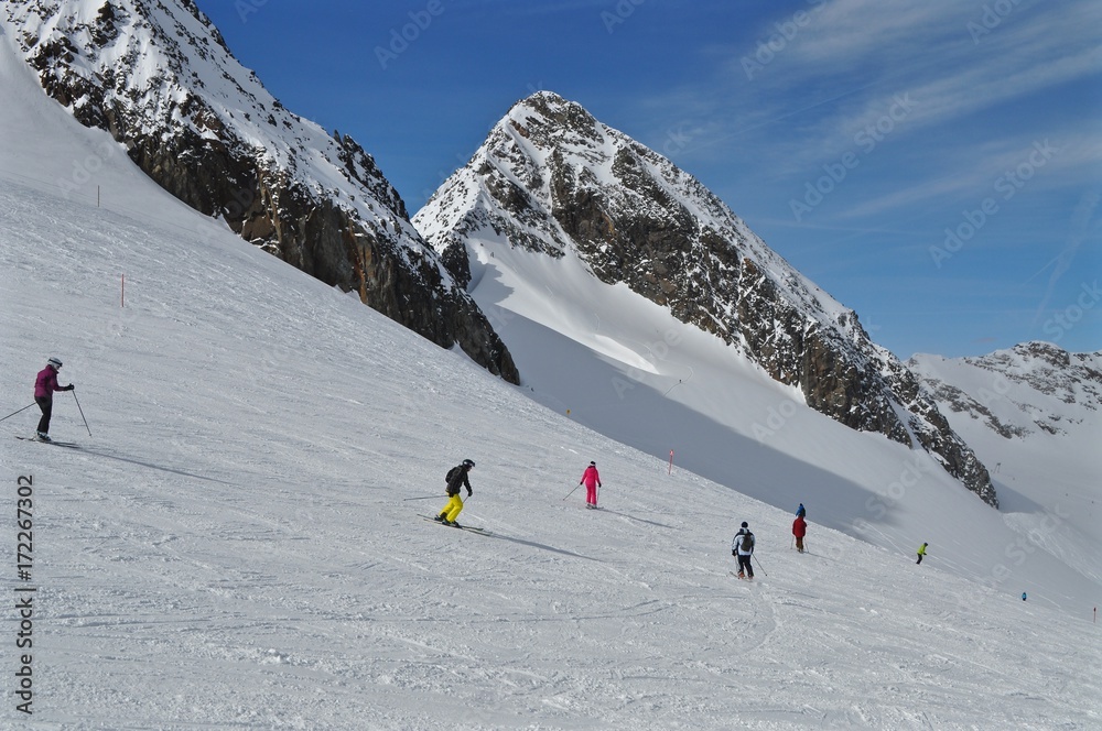 Skifahrer fahren Ski im Skigebiet Stubaier Gletscher in Österreich an den Bergen Windacher Daunkogel und Hinterer Daunkopf,  die Piste talabwärts