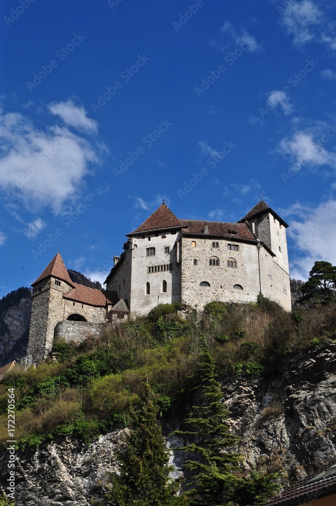 Burg Gutenberg thront auf 
Hügel vor den Bergen, in der Gemeinde Balzers im Fürstentum Liechtenstein 