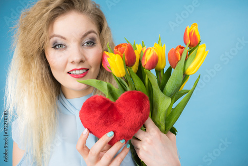 Woman holds tulips and red heart