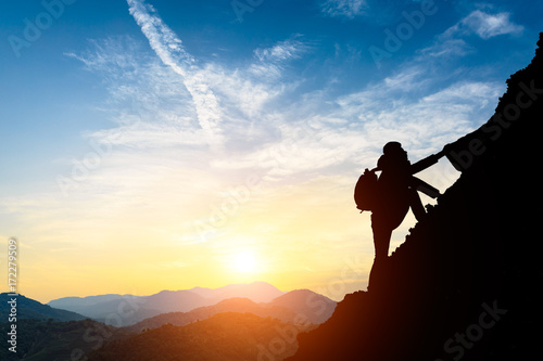 silhouette of climbing man in mountains concept of sports at beautiful sunset