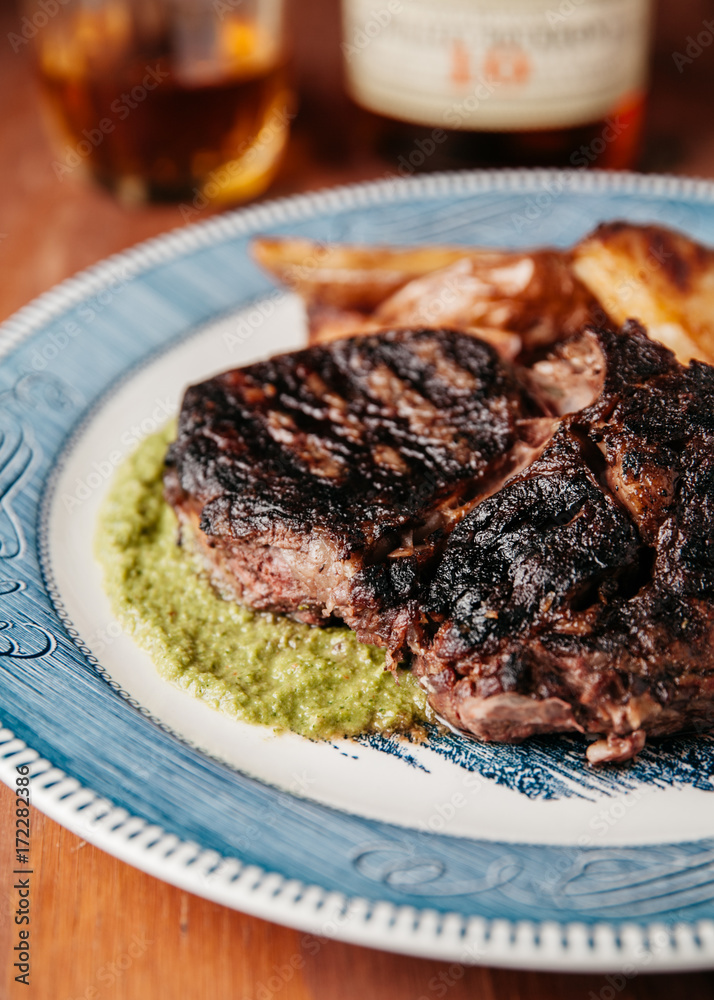 Grilled Ribeye Steak on vertical rustic background Grilled Ribeye Steak on vertical rustic background