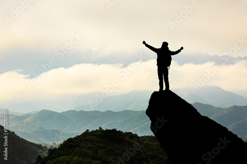 Silhouette of the man success on the peak of mountain,Sport and active life