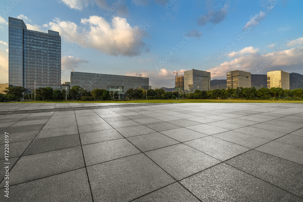 empty pavement and modern buildings in city.