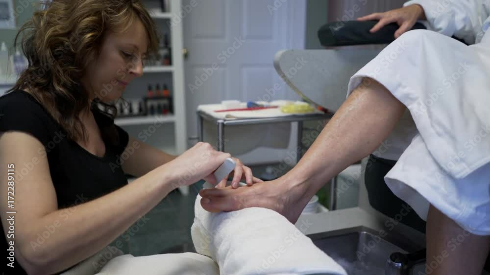 Woman gets her toenails filed.  Steadicam shot.