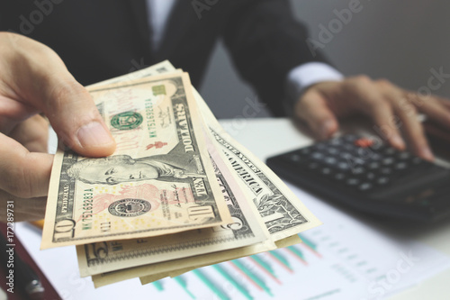 Pay the US dollar , Hand use dollar money on the office desk  investment and property for concept photo