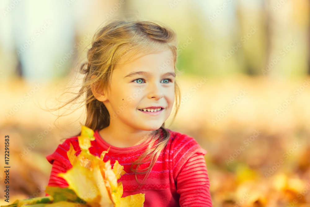 Happy little girl with autumn leaves in the park Happy little girl with autumn leaves in the park