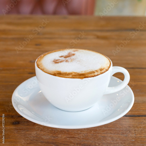 cappuccino in white coffee cup on wood table, coffee time