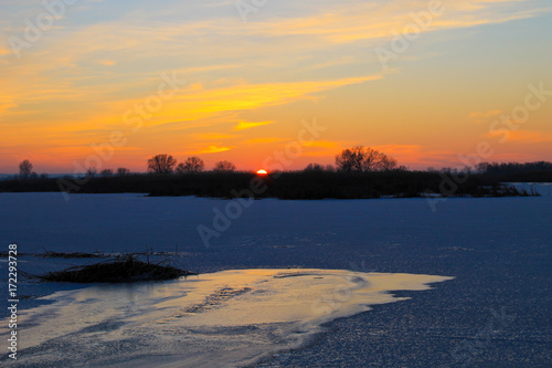 Sunset over a frozen river Dnieper on winter