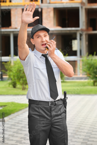 Male security guard with portable radio, outdoors