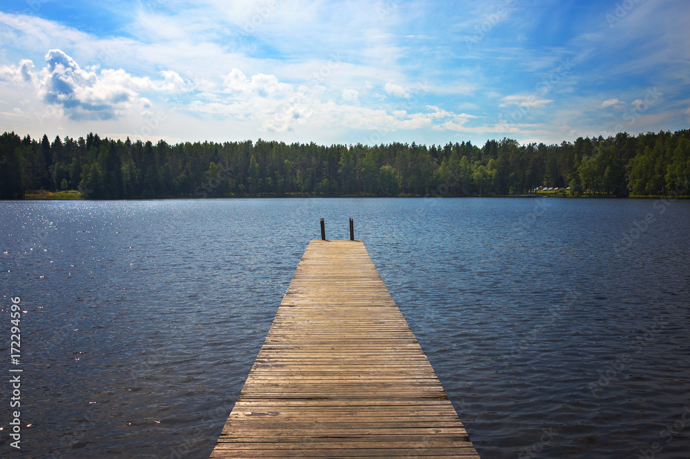 Obraz premium Old pier is on the lake in the forest