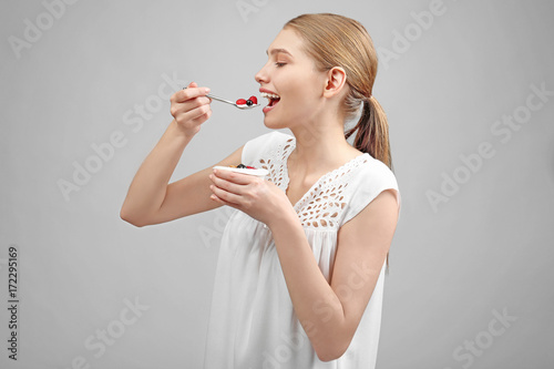 Young woman eating yogurt o...