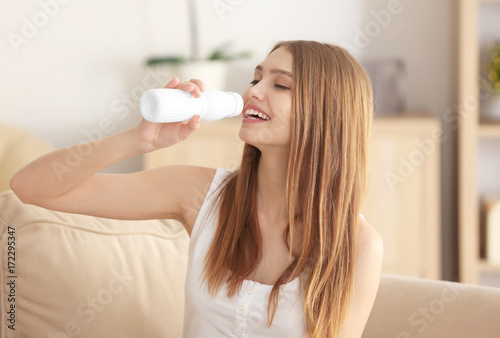 Young woman drinking yogurt...