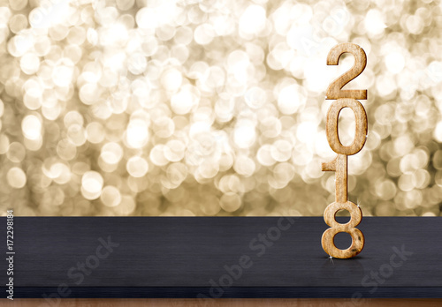 2018 new year wood number on wood table with sparkling gold bokeh wall,panoramic banner for display or montage of product.