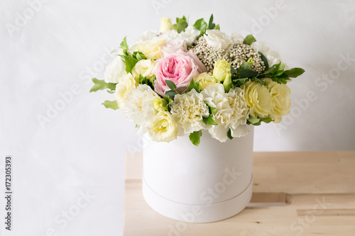 Fototapeta Naklejka Na Ścianę i Meble -  Beautiful tender bouquet of flowers in white box on light ackground with space for text