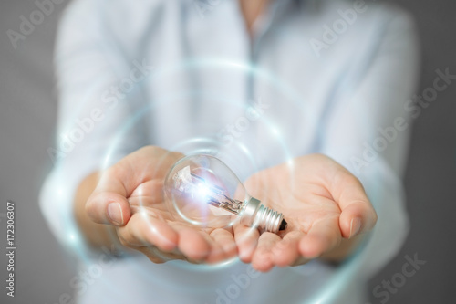 Businesswoman holding a lighbulb with connections in her hand