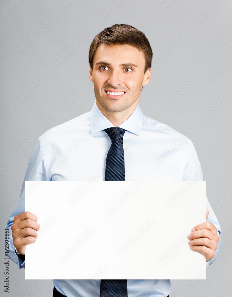 Businessman showing signboard, on gray Businessman showing signboard, on gray