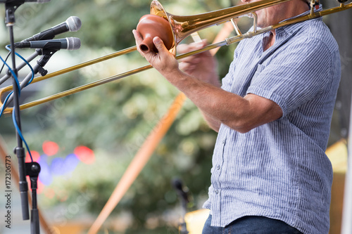 Prague, Czech Republic - August 21, 2017: musician plays on the stage the trombone with the dampener photo