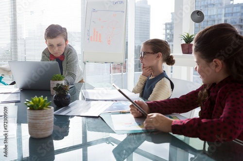 Kids as business executives interacting while meeting photo