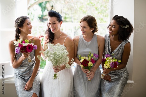 Bride and bridesmaids standing with bouquet photo
