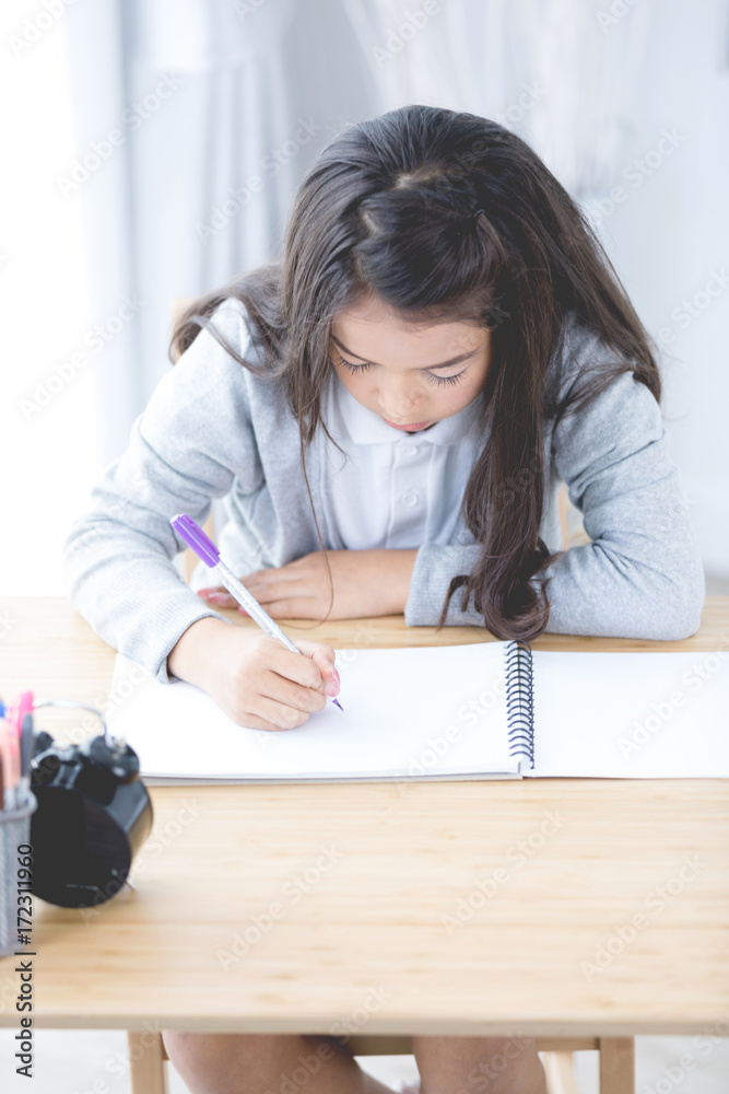 Portrait of asian cute girl doing your homework at home Portrait of asian cute girl doing your homework at home