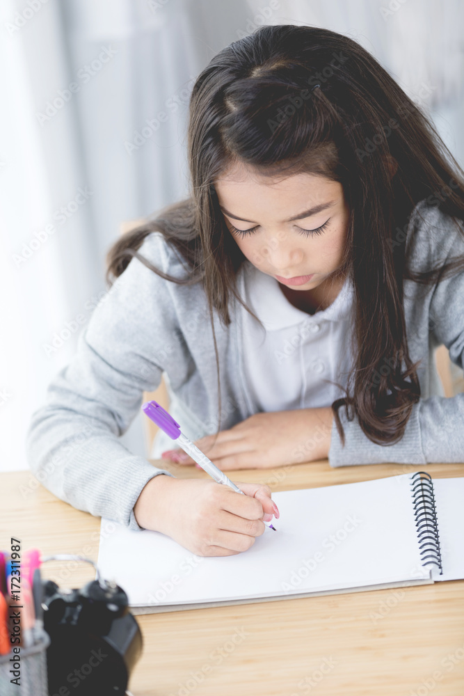 Portrait of asian cute girl doing your homework at home Portrait of asian cute girl doing your homework at home
