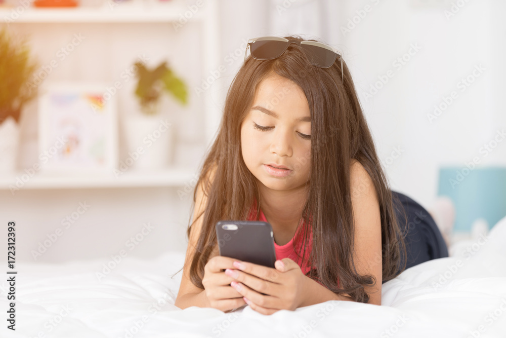 Happy asian girl reading smart phone with smile face on bed . Happy asian girl reading smart phone with smile face on bed .