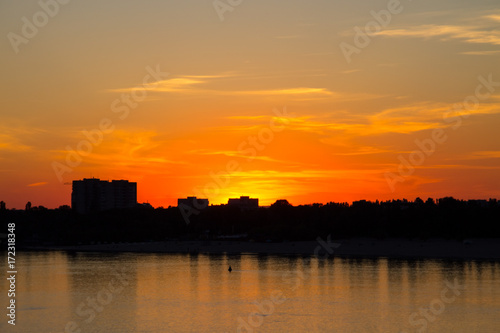Orange sunset over a river Dnieper in Kremenchug city, Ukraine © olyasolodenko