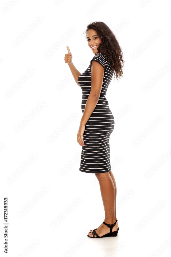 Profile of young and pretty dark skinned woman showing thumbs up on white background Profile of young and pretty dark skinned woman showing thumbs up on white background