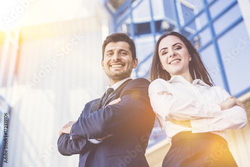 The happy man and woman stand on the background of the office center