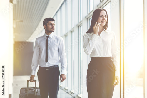 The business woman phone near the man with a suitcase