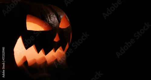 Shining Jack-O-Lantern. Halloween pumpkin with scary face isolated on the black background