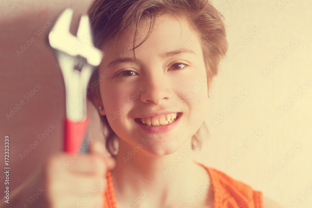 Girl teenager in an orange blouse holding wrench in the hands. Toned Girl teenager in an orange blouse holding wrench in the hands. Toned