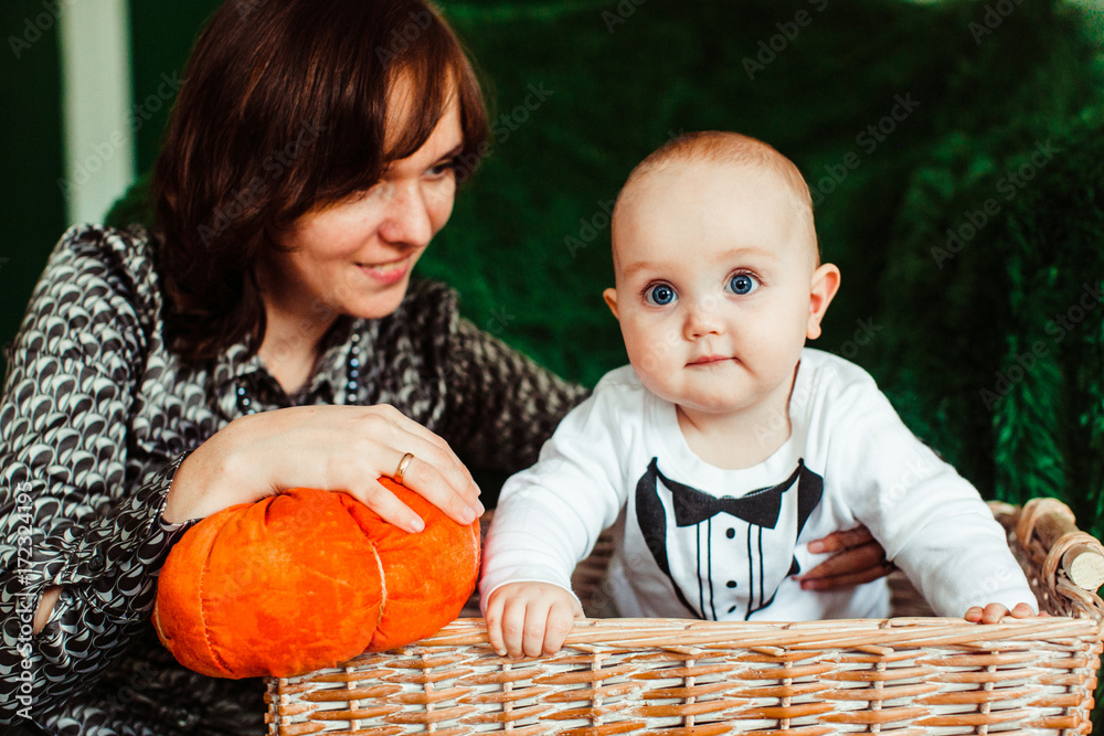 Fototapeta premium Mother plays with little son in the basket