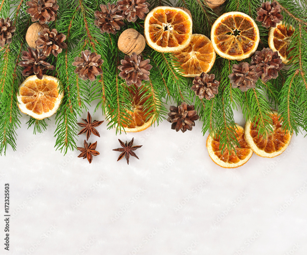 Nuts, dried oranges and cones and spruse branch on a white