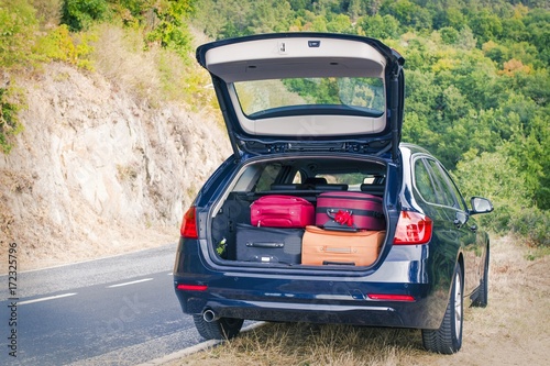 car with trunk loaded with suitcases and luggage