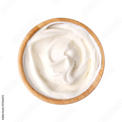 Sour cream in a wooden bowl isolated on white.