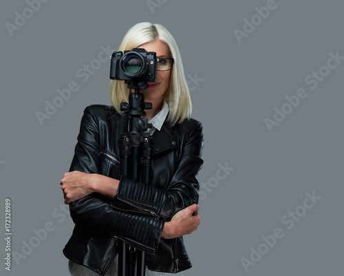 Blond photographer female on a grey background.