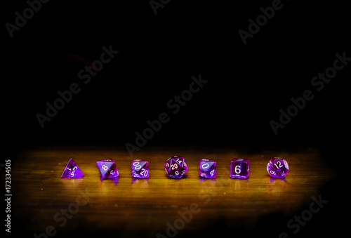 dadi viola in fila con luce e sfondo nero photo