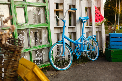 The decoration of vintage bicycle and white building with green door. Old blue retro bike and holiday house background. photo